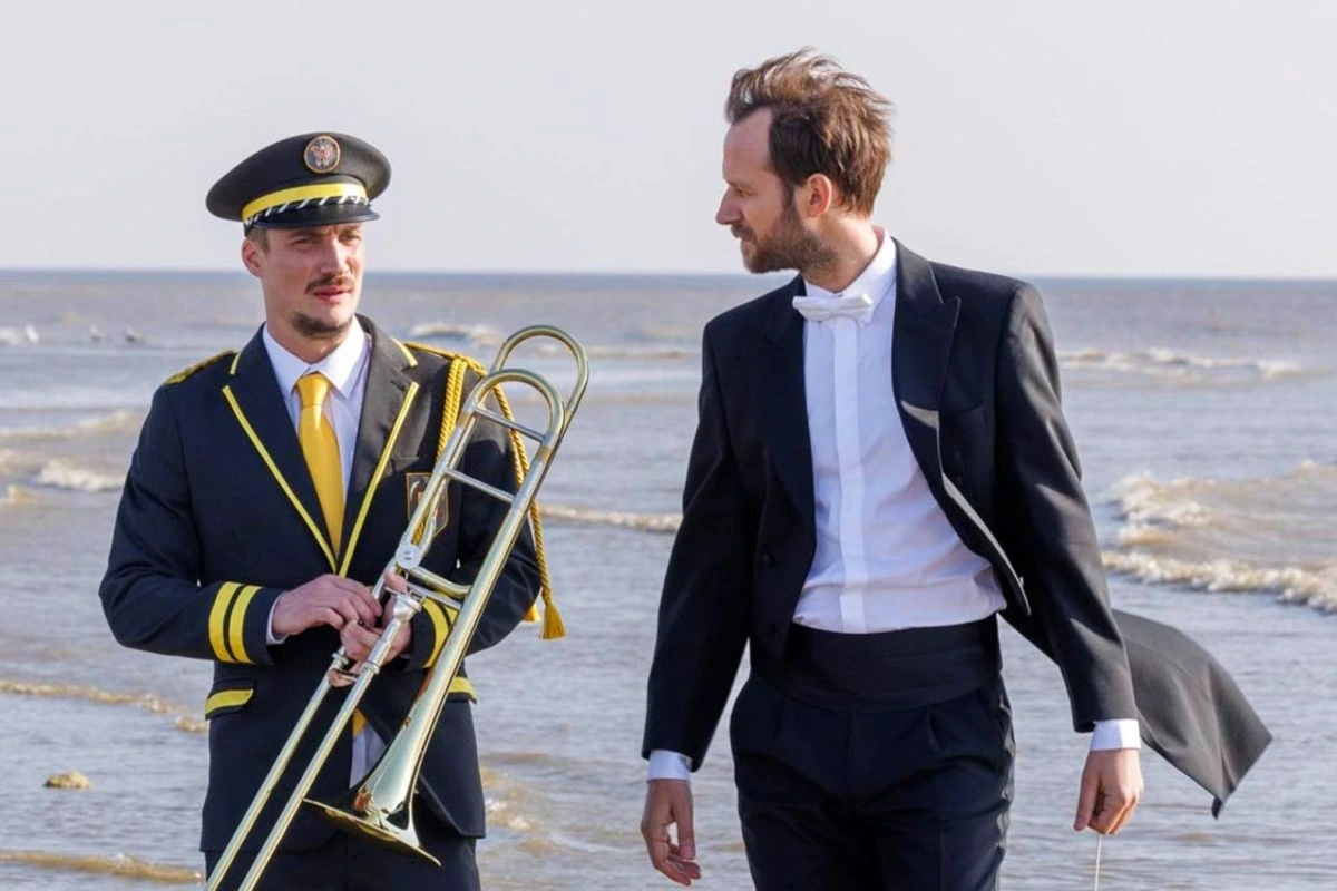 Szene aus dem Film "Die leisen und die großen Töne" mit zwei Männern in Unifrom und Frack am Strand (Foto: Neue Visionen Filmverleih)