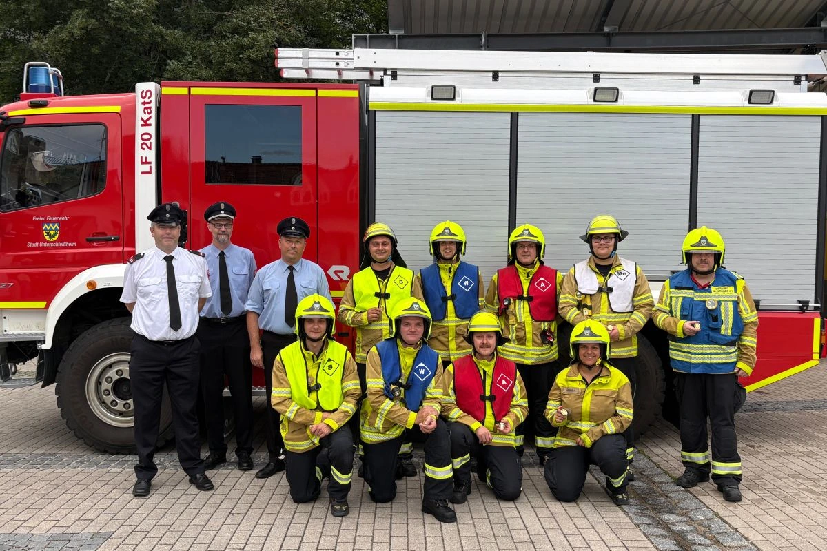Gruppe von Feuerwehrleuten vor Feuerwehr-Fahrzeug (Foto: FFU)