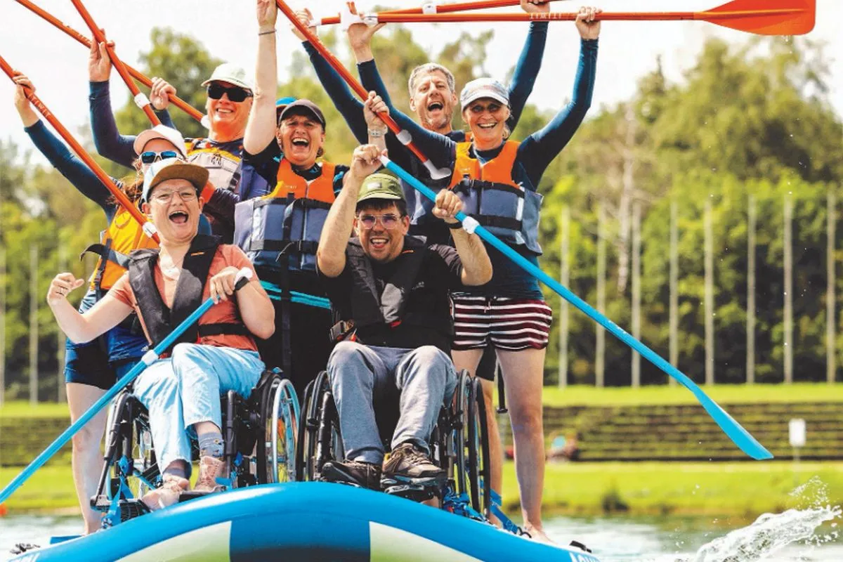 Menschen mit und ohne Behinderung auf einem auch für Rollstuhlfahrer geeigneten Stand -Up-Paddel (Foto: Carina Pilz, Copyright: Stiftung Pfennigparade)