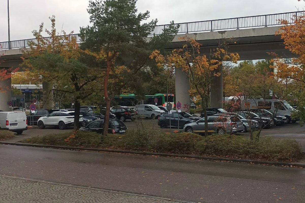 Autos auf der Parkfläche unter der Le-Crès-Brücke in Unterschleißheim