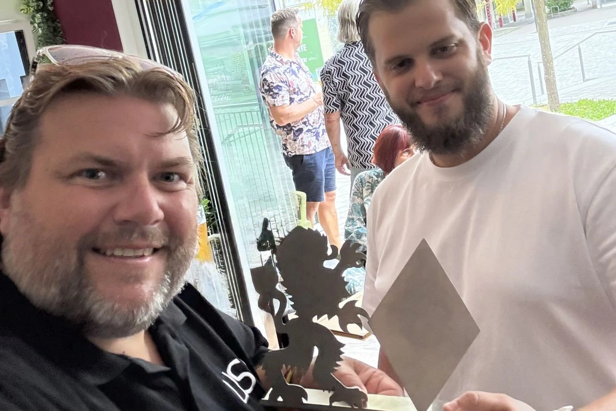 Stefan Krimmer übergibt einen aus Metall gefrästen bayerischen Löwen an Mario Krüger.
