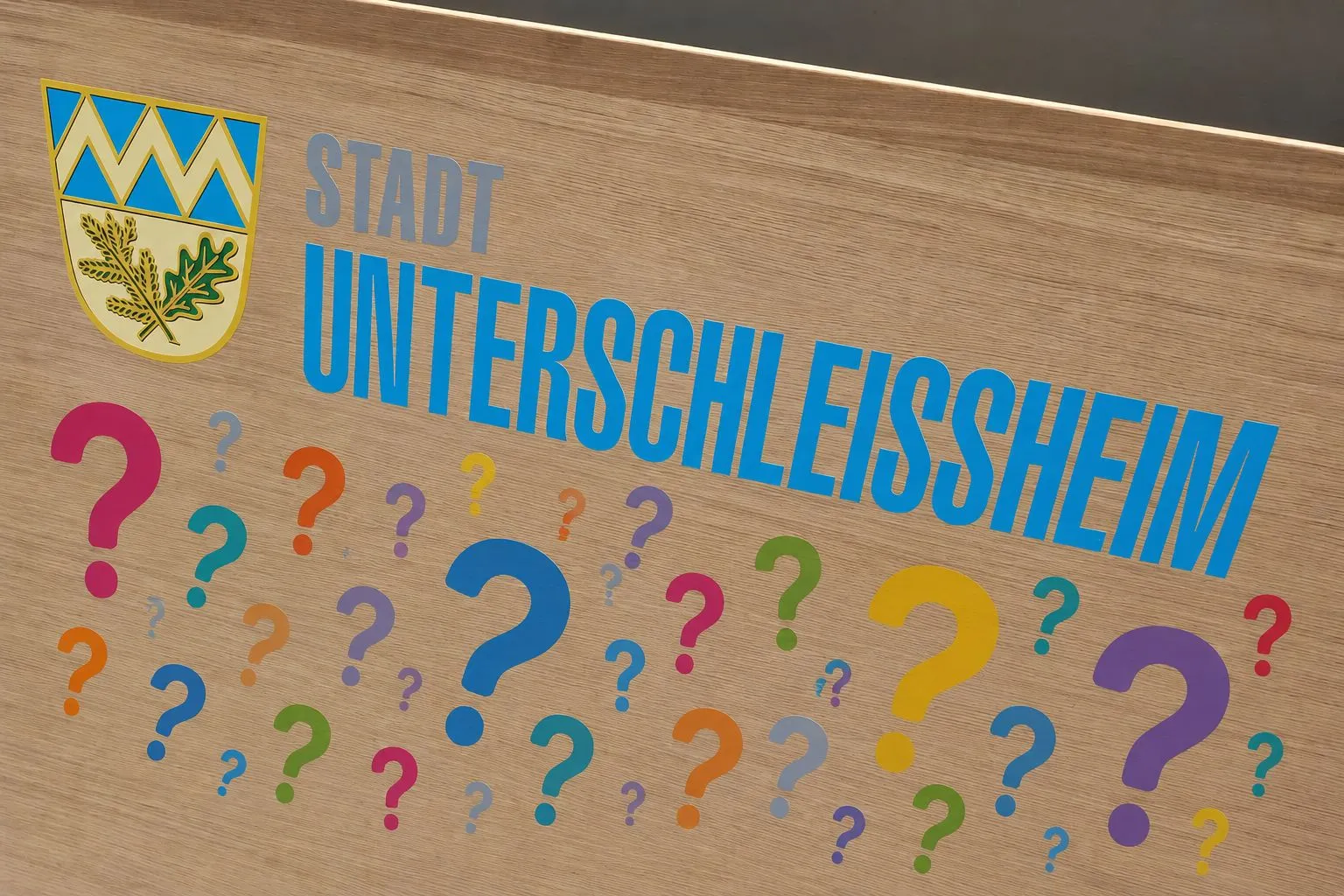 Symbolbild für die Bürgerfragestunde in Unterschleißheim mit Stadtwappen und Fragezeichen (Foto und Bearbeitung: Peter Marwan)