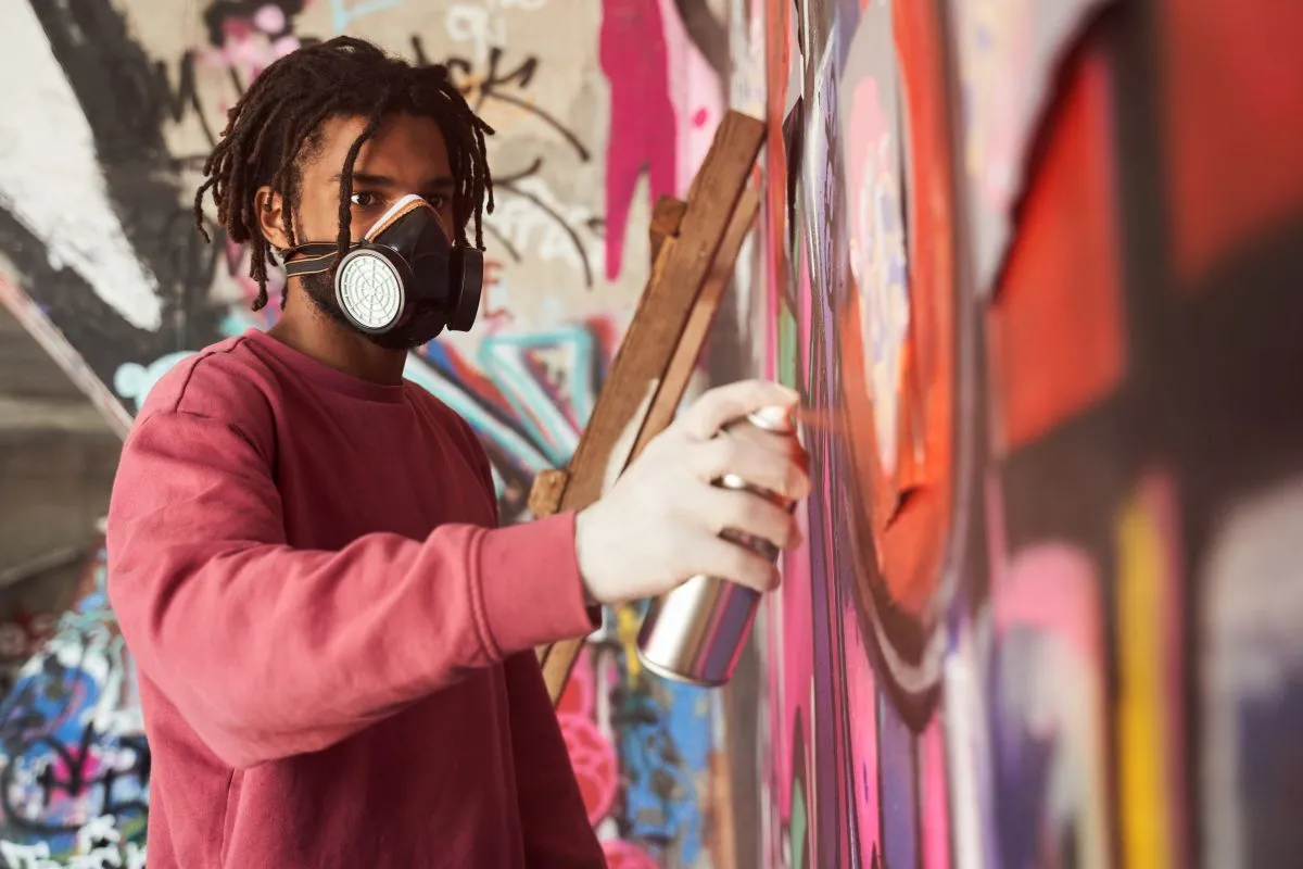 Jugendlicher beim Sprühen von Graffiti auf einer Wand. (Foto: Bezirk Oberbayern / ZAMMA-Festival)