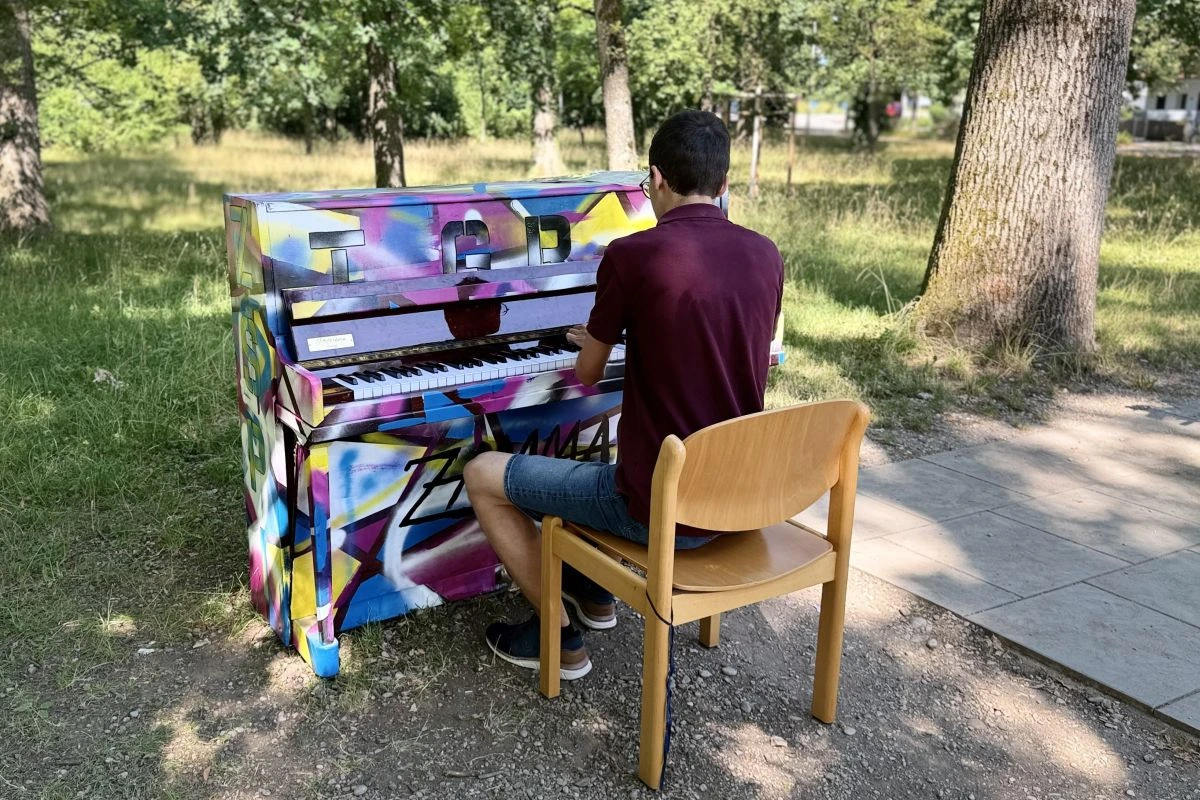Das Streetpiano im Lohwald fand regen Anklang. Hier spielt der 19-jährige Sebastian ein paar Stücke auswendig. (Foto: Ann-Kristin Höger / © Bezirk Oberbayern)